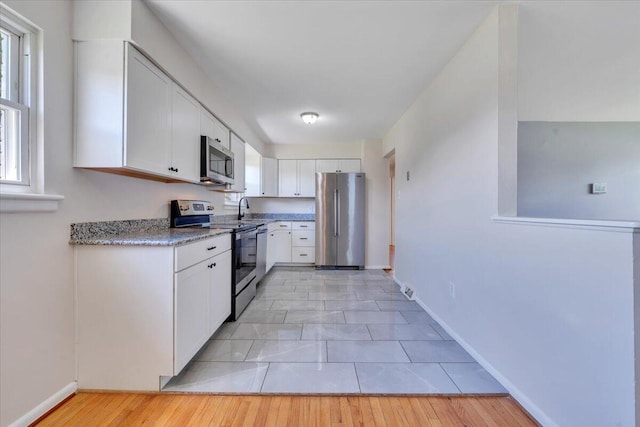 3734 Long Meadow Ave NW, Roanoke, VA 24017 - kitchen with stainless steel appliances, white cabinetry, a sink, and baseboards