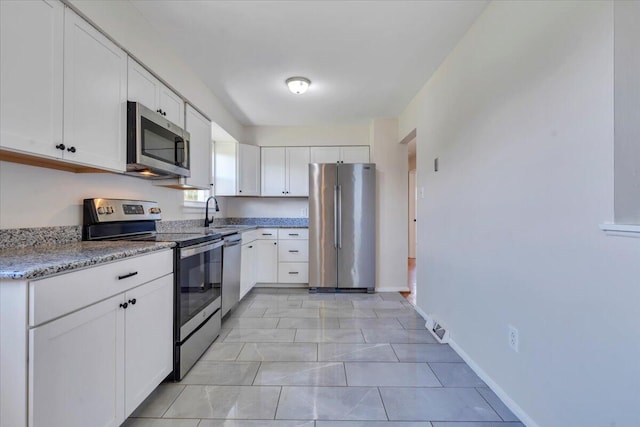 3734 Long Meadow Ave NW, Roanoke, VA 24017 - kitchen featuring appliances with stainless steel finishes, white cabinetry, light stone counters, and baseboards