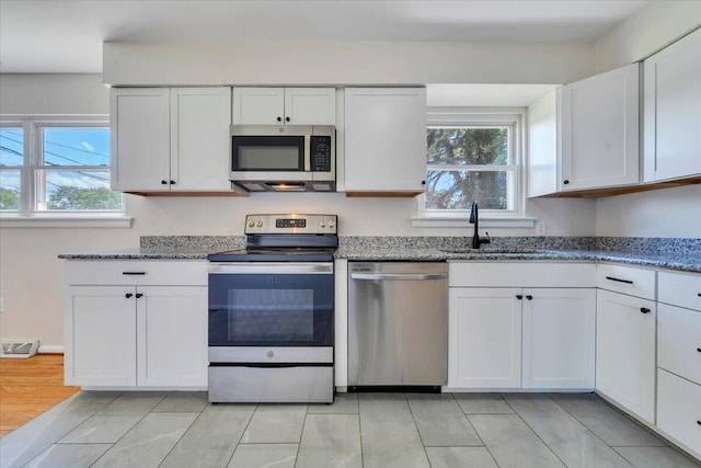 3734 Long Meadow Ave NW, Roanoke, VA 24017 - kitchen with appliances with stainless steel finishes, a sink, light stone countertops, and white cabinetry