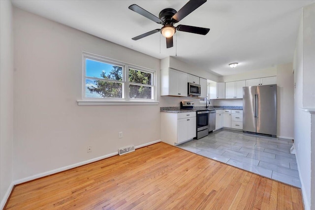 3734 Long Meadow Ave NW, Roanoke, VA 24017 - kitchen with stainless steel appliances, light wood-style flooring, white cabinetry, and ceiling fan