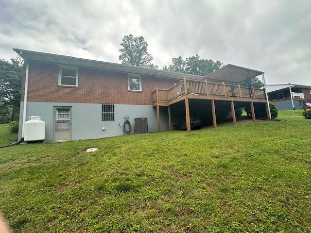 586 Graceland Dr, Bassett, VA 24055 - back of property featuring a deck, a yard, brick siding, and central AC unit