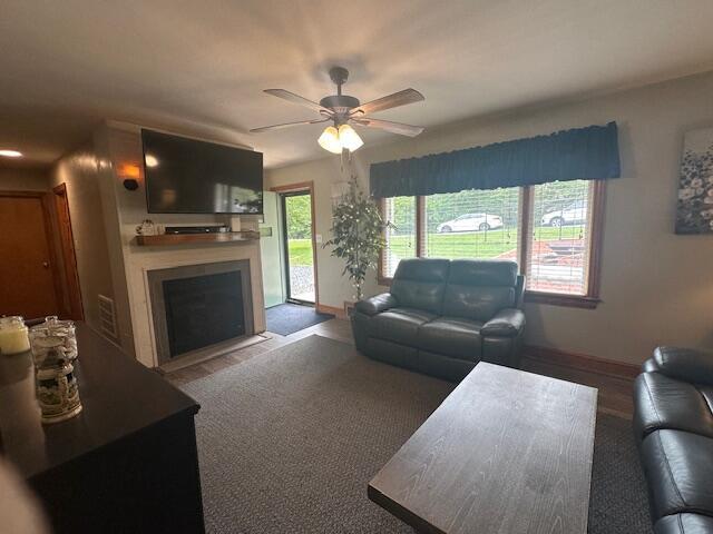 586 Graceland Dr, Bassett, VA 24055 - living area featuring baseboards, a fireplace with flush hearth, and a ceiling fan