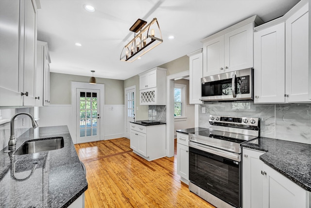 4816 Colonial Ave, Roanoke, VA 24018 - kitchen featuring stainless steel appliances, a sink, light wood finished floors, decorative backsplash, and healthy amount of natural light
