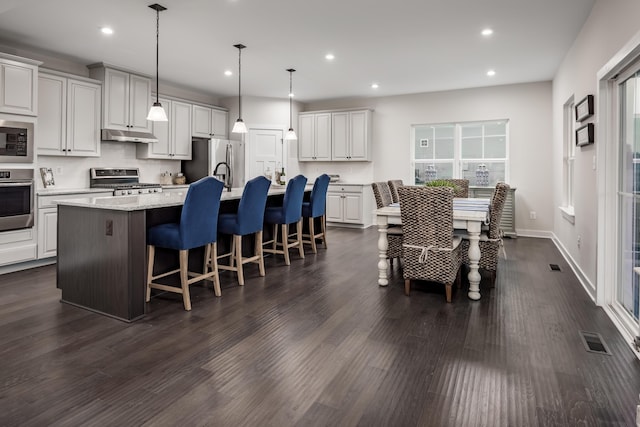 7229 Fairway Ridge Cir, Salem, VA 24153 - kitchen featuring appliances with stainless steel finishes, an island with sink, recessed lighting, dark wood-style flooring, and white cabinetry