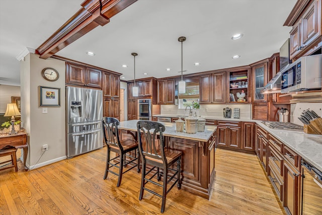 402 Anchor Dr, Moneta, VA 24121 - kitchen featuring appliances with stainless steel finishes, backsplash, a center island, a breakfast bar, and light stone countertops