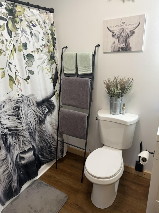7506 Roaring Run Rd Unit 1, Covington, VA 24426 - full bath featuring wood finished floors, toilet, baseboards, and curtained shower