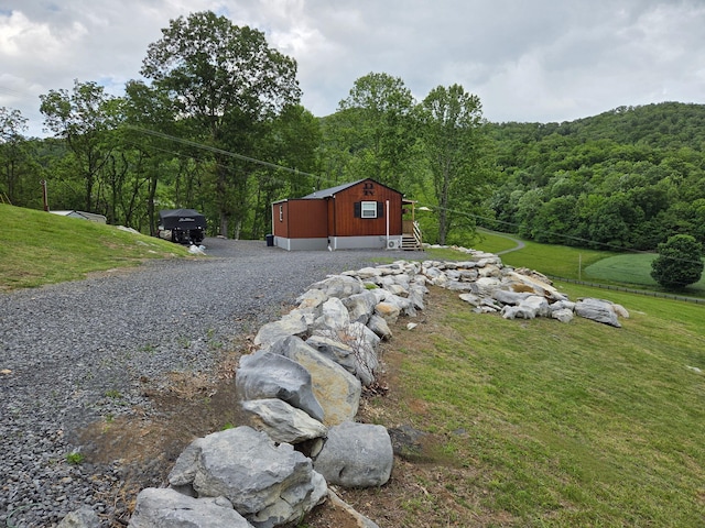 7506 Roaring Run Rd Unit 1, Covington, VA 24426 - view of property exterior with a wooded view, entry steps, a lawn, and gravel driveway