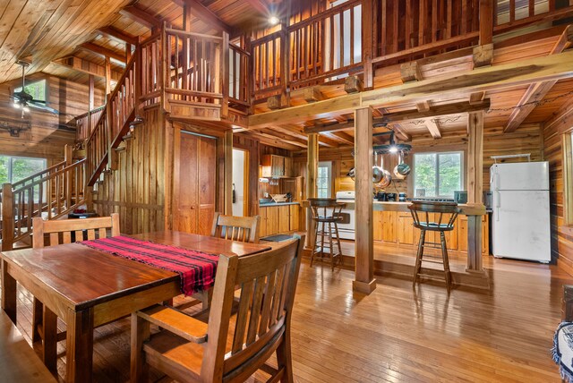 1539 Wheats Valley Rd, Bedford, VA 24523 - dining space featuring wood walls, stairs, wood ceiling with exposed beams, light wood-style flooring, and a ceiling fan