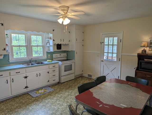 150 Harvey St, Rocky Mount, VA 24151 - kitchen featuring white electric range, a sink, open shelves, a wainscoted wall, and white cabinetry