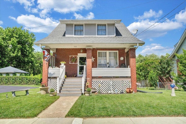 702 Arbutus Ave SE, Roanoke, VA 24014 - bungalow featuring a porch, brick siding, a front lawn, and a shingled roof