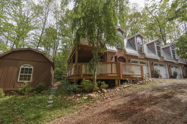 157 Burks Hollow Rd SW, Willis, VA 24380 - back of property featuring metal roof, driveway, brick siding, a garage, and a deck