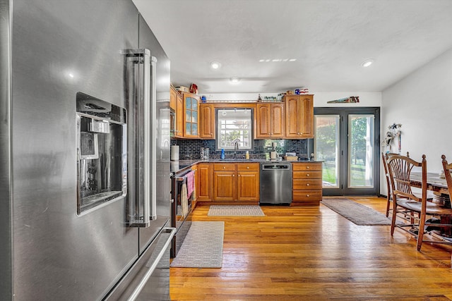 22 Spring Branch Ln, Fincastle, VA 24090 - kitchen with appliances with stainless steel finishes, brown cabinetry, light wood-style floors, backsplash, and dark countertops