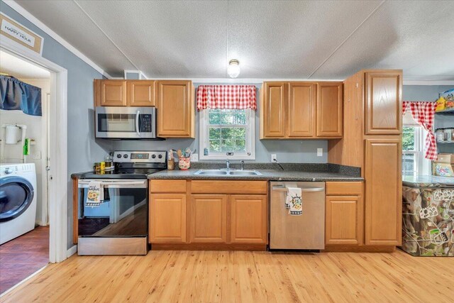4362 Stewartsville Rd, Moneta, VA 24121 - kitchen with appliances with stainless steel finishes, washer / clothes dryer, a sink, dark countertops, and crown molding