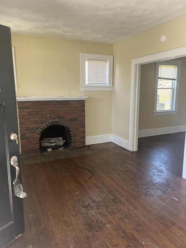 2816 10th St NW, Roanoke, VA 24012 - unfurnished living room with hardwood / wood-style flooring, baseboards, and a brick fireplace