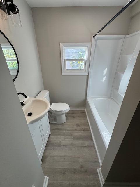 2207 Melrose Ave NW, Roanoke, VA 24017 - full bath featuring toilet, vanity, wood finished floors, shower / tub combination, and baseboards