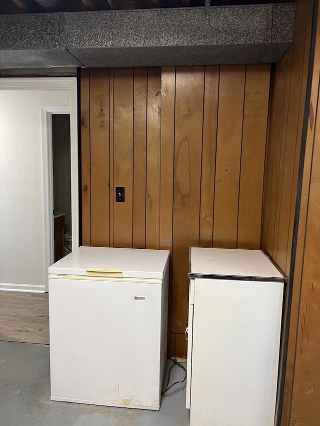 1878 Cranwell Dr, Vinton, VA 24179 - detailed view of concrete floors, white fridge, wooden walls, and baseboards