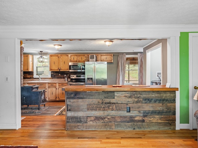 6357 Breckinridge Mill Rd, Fincastle, VA 24090 - kitchen featuring appliances with stainless steel finishes, ornamental molding, wood finished floors, a textured ceiling, and backsplash