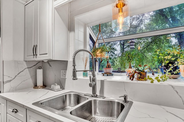 2440 Charing Cross Dr, Roanoke, VA 24018 - kitchen view of a sink, white cabinets, decorative backsplash, and light stone counters