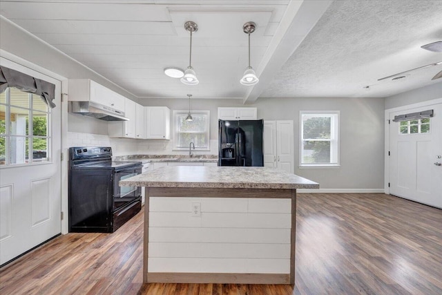 1006 10th St, Glasgow, VA 24555 - kitchen with black appliances, under cabinet range hood, a sink, healthy amount of natural light, and beamed ceiling