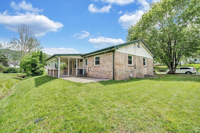 1006 10th St, Glasgow, VA 24555 - back of house with central air condition unit, brick siding, a lawn, and a porch