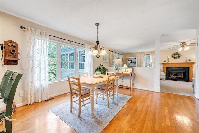 610 Crystal Anne Ln, Roanoke, VA 24019 - dining space with a fireplace, baseboards, light wood-style flooring, a chandelier, and ceiling fan