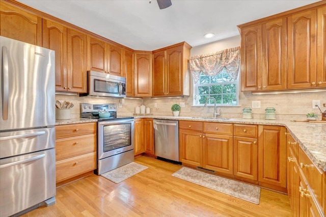610 Crystal Anne Ln, Roanoke, VA 24019 - kitchen with stainless steel appliances, a sink, light stone countertops, backsplash, and light wood-style flooring