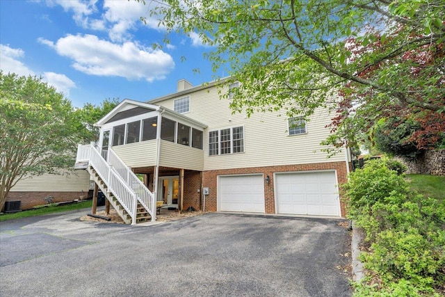 610 Crystal Anne Ln, Roanoke, VA 24019 - view of front of property with a sunroom, driveway, a garage, and brick siding