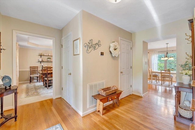 610 Crystal Anne Ln, Roanoke, VA 24019 - hallway with light wood-style floors, a chandelier, and baseboards