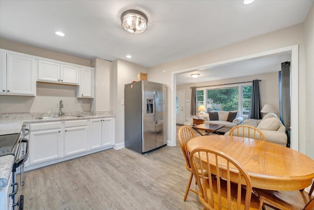3023 Birchlawn Ave NW, Roanoke, VA 24012 - kitchen featuring appliances with stainless steel finishes, a sink, white cabinetry, light wood-style flooring, and light stone counters