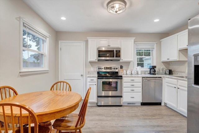 3023 Birchlawn Ave NW, Roanoke, VA 24012 - kitchen featuring appliances with stainless steel finishes, white cabinets, light wood finished floors, recessed lighting, and light stone countertops