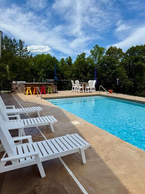 1038 Lees Mill Ln, Goode, VA 24556 - community pool featuring a patio area and view of wooded area