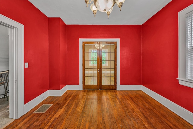 1129 Howbert Ave SW, Roanoke, VA 24015 - unfurnished room with a chandelier, french doors, wood finished floors, and baseboards
