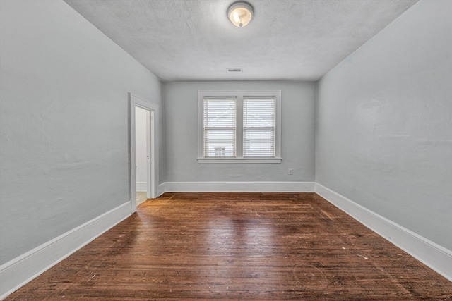 1129 Howbert Ave SW, Roanoke, VA 24015 - unfurnished room with dark wood-type flooring, baseboards, and a textured ceiling