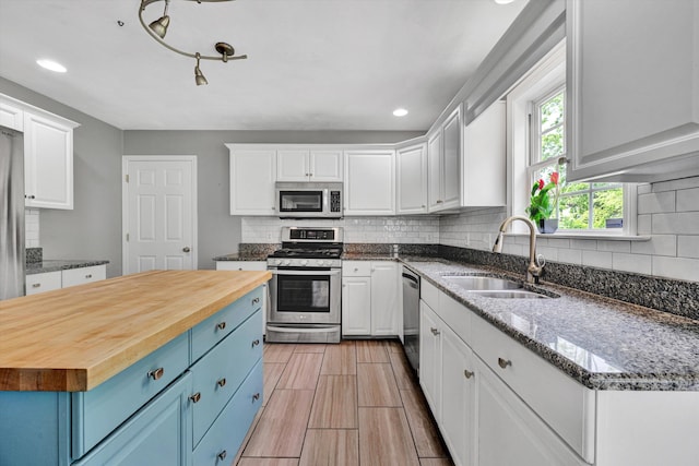 135 Sapphire Ave, Christiansburg, VA 24073 - kitchen with appliances with stainless steel finishes, a sink, wooden counters, blue cabinets, and recessed lighting