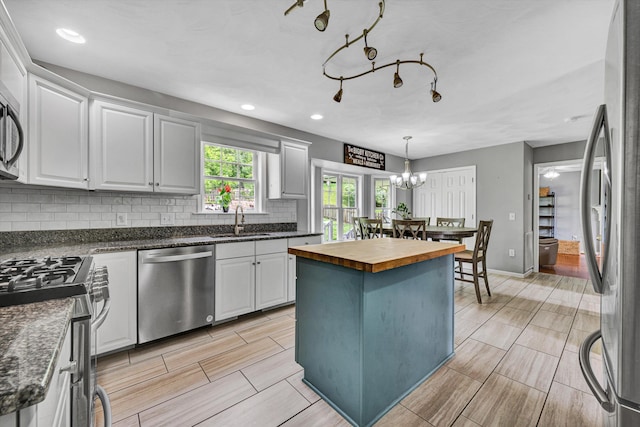 135 Sapphire Ave, Christiansburg, VA 24073 - kitchen featuring appliances with stainless steel finishes, wood counters, a sink, decorative backsplash, and a center island