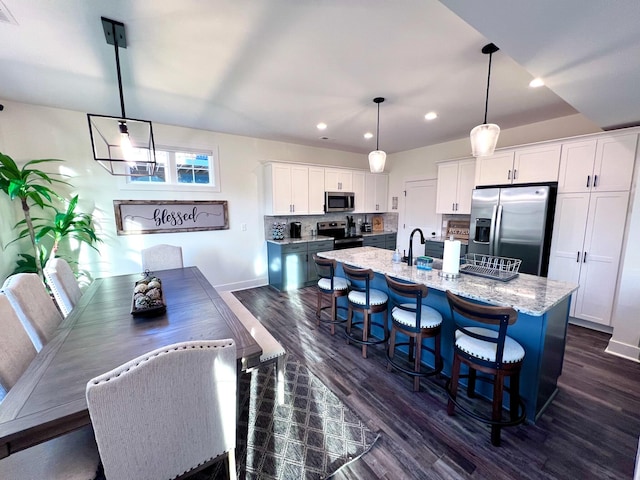 103 Retreat Ln, Huddleston, VA 24104 - kitchen with appliances with stainless steel finishes, recessed lighting, an island with sink, dark wood-type flooring, and white cabinets