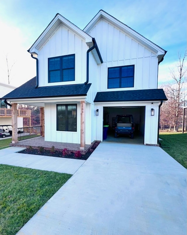 103 Retreat Ln, Huddleston, VA 24104 - modern inspired farmhouse with concrete driveway, a front yard, an attached garage, and board and batten siding