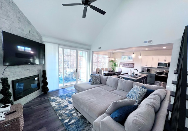 103 Retreat Ln, Huddleston, VA 24104 - living room with high vaulted ceiling, ceiling fan, a fireplace, plenty of natural light, and dark wood-type flooring