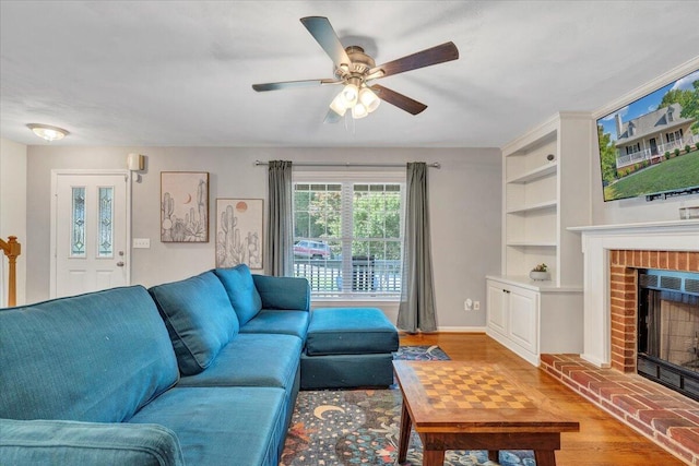828 Ray St, Roanoke, VA 24019 - living room with a brick fireplace, a ceiling fan, baseboards, and wood finished floors