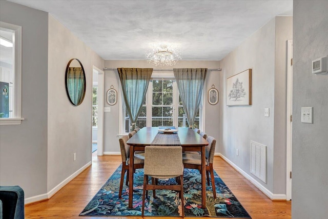 828 Ray St, Roanoke, VA 24019 - dining area with a chandelier, light wood-style floors, and baseboards