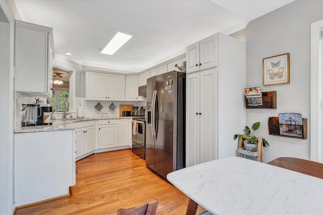 828 Ray St, Roanoke, VA 24019 - kitchen with stainless steel appliances, light wood-type flooring, a sink, backsplash, and ornamental molding