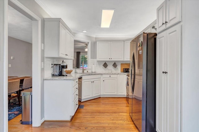 828 Ray St, Roanoke, VA 24019 - kitchen featuring appliances with stainless steel finishes, light wood finished floors, a sink, decorative backsplash, and ornamental molding