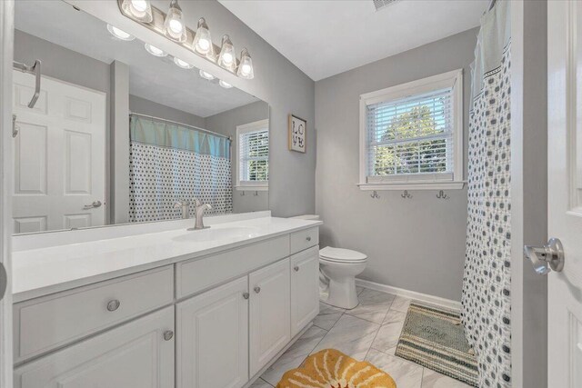 828 Ray St, Roanoke, VA 24019 - bathroom featuring vanity, toilet, baseboards, marble finish floors, and curtained shower