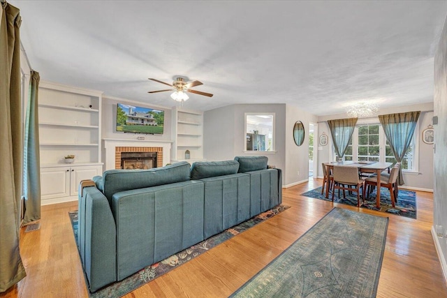 828 Ray St, Roanoke, VA 24019 - living area with baseboards, a ceiling fan, a fireplace, built in features, and wood finished floors