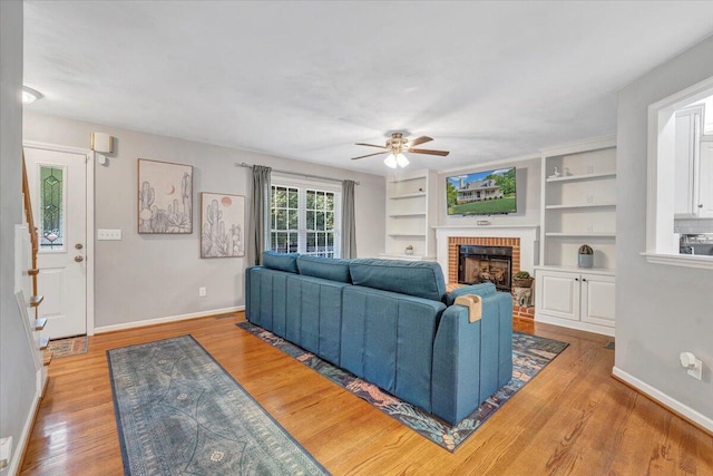 828 Ray St, Roanoke, VA 24019 - living room featuring a ceiling fan, a brick fireplace, light wood-type flooring, baseboards, and built in features