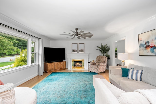 2561 Inglewood Rd SW, Roanoke, VA 24015 - living room with light wood-type flooring, a ceiling fan, ornamental molding, a warm lit fireplace, and baseboards