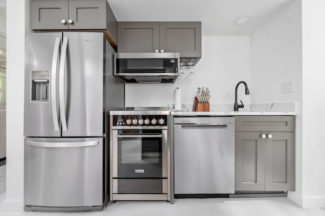 2561 Inglewood Rd SW, Roanoke, VA 24015 - kitchen with appliances with stainless steel finishes, gray cabinetry, a sink, and light stone counters
