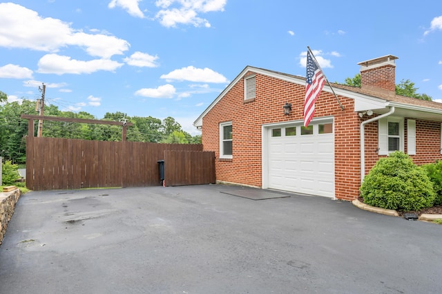 2561 Inglewood Rd SW, Roanoke, VA 24015 - view of side of home featuring brick siding, a chimney, a garage, and asphalt driveway