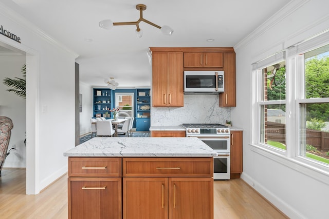 2561 Inglewood Rd SW, Roanoke, VA 24015 - kitchen with range with two ovens, stainless steel microwave, light wood finished floors, tasteful backsplash, and ornamental molding