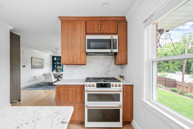 2561 Inglewood Rd SW, Roanoke, VA 24015 - kitchen with double oven range, stainless steel microwave, light wood-style floors, backsplash, and brown cabinetry